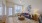 living area with a large window, coffee table and chair